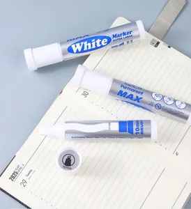 Macro detail of white permanent markers with 10mm brush tips laid on a planner page