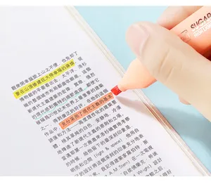 Close-up of pastel orange highlighter pen marking Chinese text in a book detail