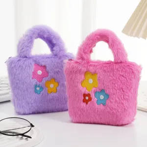 Detailopname van roze en paarse pluche mini-handtassen voor kinderen met bloemborduurwerk