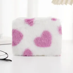 Nahaufnahme einer weichen, weißen Plüschtasche mit einem süßen rosa Herzmuster-Design