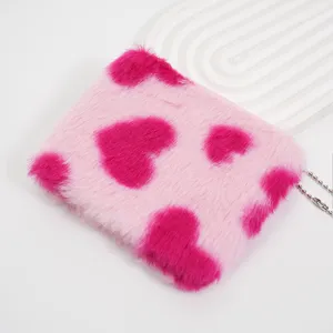 Nahaufnahme einer niedlichen quadratischen Plüsch-Geldbörse mit rosa Herzmuster und Fell