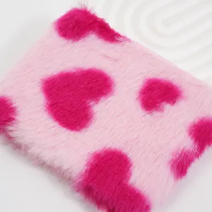 Detailaufnahme der rosa Plüschtasche mit magentafarbenen Herzmustern und weicher Textur