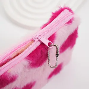 Nahaufnahme von flauschiger rosa Herzmuster-Geldbörse mit Reißverschluss und Kette