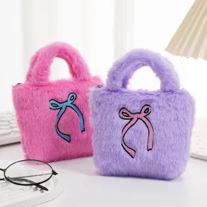 Detail van schattige pluche handtassen met geborduurde strikken in roze en paars