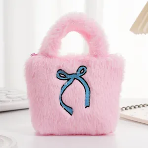 Detail van de zachte roze pluche mini handtas met een blauw geborduurde strik erop