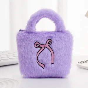 Detail van zachte paarse pluche textuur en roze geborduurde strik op mini handtas.