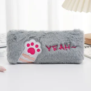 Detailed macro view of a grey fluffy cat paw pencil case with pink embroidery