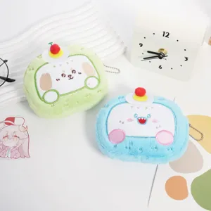 Due carini portamonete in peluche a forma di torta animale verde e blu con pompon.