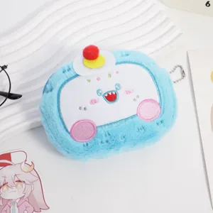 Primo piano di un simpatico portamonete in peluche blu con dettaglio viso ricamato