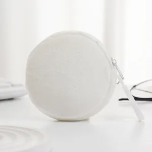 Nahaufnahme einer minimalistischen weißen runden Plüsch-Minigeldbörse mit Reißverschluss