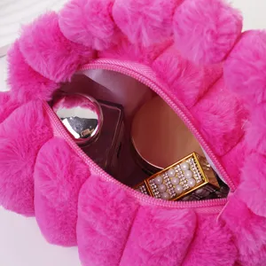 Detail des Innenraums einer pinkfarbenen Plüschtasche mit Make-up und weicher Textur.