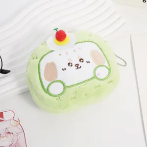 Primo piano di un simpatico portamonete in peluche verde con faccia di cane ricamata