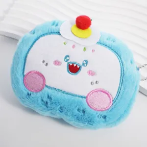 Dettaglio ravvicinato del simpatico portamonete in peluche blu con faccia a fumetti.