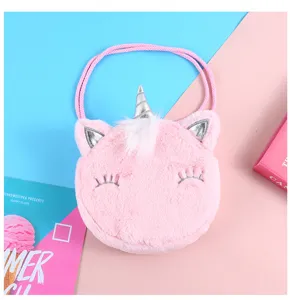 Primo piano di una borsa a tracolla unicorno in peluche rosa con corno argento ricamato