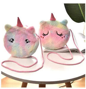 Two round plush unicorn crossbody bags featuring colorful tie-dye fur on a clean white table