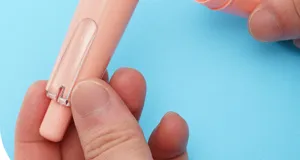 Nahaufnahme eines pinkfarbenen, druckbaren Korrekturbands auf blauem Grund