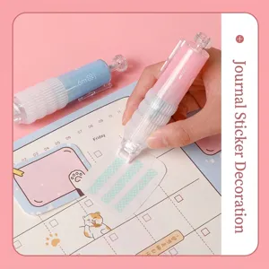 Close-up of a pink press-type dot glue tape pen being used for scrapbooking crafts