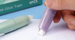 Detailaufnahme der Anwendung eines lila Punktklebebands in Stiftform auf Papier