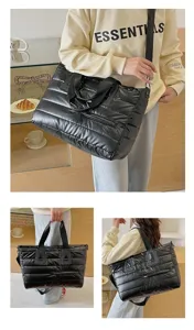 Large black quilted puffer tote bag with adjustable shoulder strap and handles for women