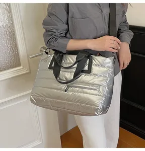 Detailed shot of a silver metallic puffer tote bag featuring quilted texture and zipper detail