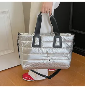 Metallic silver puffer tote bag with quilted design and black shoulder straps.