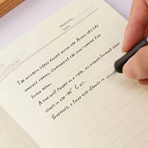 Primer plano de un bolígrafo de gel negro de 0,7 mm que escribe con fluidez en un cuaderno