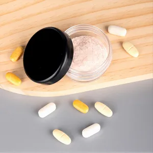 Portable manual pill grinder crusher detail showing crushed pink powder for easier swallowing