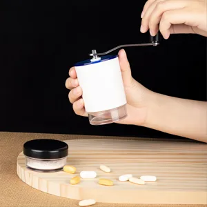Close-up view of a person using a portable manual pill grinder for medicine tablets.
