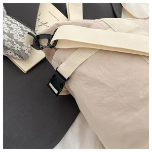 Detail view of beige travel bag strap and black buckle, showing durable fabric and hardware.