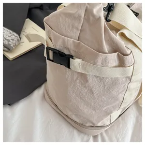 Close-up detail view of large capacity travel duffel bag with durable straps and buckle, beige.