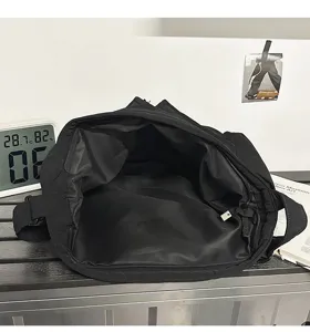 Interior view of a large black canvas crossbody bag showing spacious main compartment