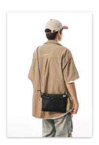 Detailed back view of a black Japanese style street mesh crossbody bag on a male model