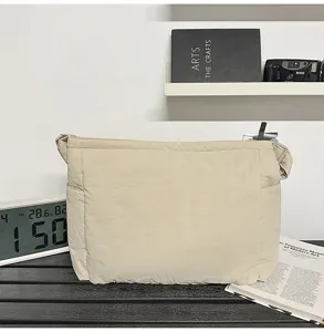 Front view of a beige retro canvas messenger bag displayed in a minimalist indoor setting