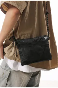 Black Japanese style utilitarian crossbody bag with mesh pocket and reflective patch