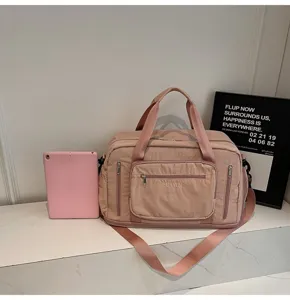 Detail view of pink large capacity travel bag with a tablet for size reference