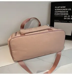 Close-up view of the dusty rose large capacity travel duffel bag on a marble surface.