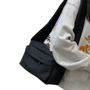 Simple black canvas messenger bag with a stylish wide strap for women crossbody wear.