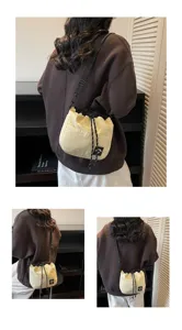 Model draagt een casual crème nylon bucketbag met trekkoord en verstelbare riem