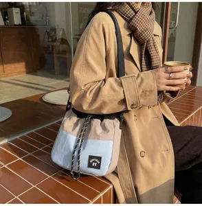 Casual Japanse nylon bucket bag met trekkoord gedragen door model in straatsetting