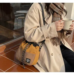 Japanse stijl nylon bucket bag met trekkoord in bruin en geel gedragen door een model