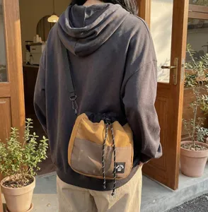 Detailweergave van een Japanse nylon crossbody emmertas met trekkoord in bruin