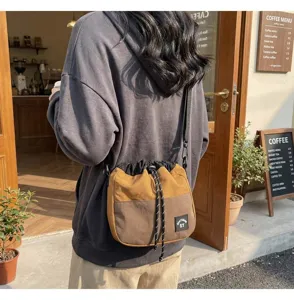 Japanse stijl nylon bucket bag met trekkoord gedragen in een gezellige cafe-setting.