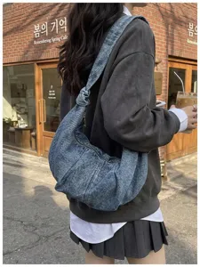 Stylish denim hobo bag with a knotted strap detail worn in a casual lifestyle setting