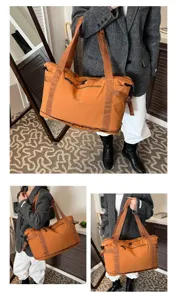 Detailed view of large capacity orange travel duffel bag showing shoulder strap and zipper design.