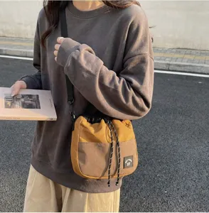 Japanse stijl nylon crossbodytas met trekkoord in een lifestyle straatsetting detail