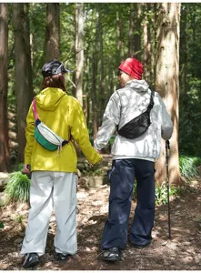 Outdoor scenario of a couple wearing colorful and black sports crossbody fanny packs in a forest