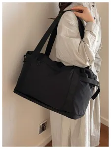 Black large capacity travel duffel bag with shoulder strap, ideal for daily commute, lightweight.
