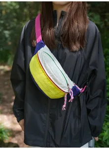Colorful dopamine-style sporty sling bag shown on model in a natural outdoor setting