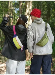 Couple wearing colorful outdoor sports fanny packs in a forest lifestyle setting.