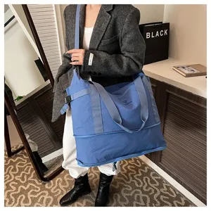 Large capacity blue travel tote bag detailed view showcasing durable fabric and shoulder straps.